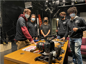 5 students stand ready behind a C70 camera and other gear